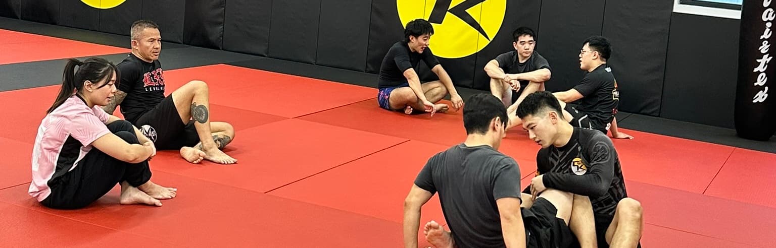 Students sitting on the mats between rounds at Cabra Kai